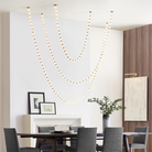 The Collier 108 Chandelier from Visual Comfort and Co in natural brass in a dining room.