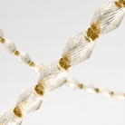 The Collier 84 Chandelier from Visual Comfort and Co in natural brass in detail.