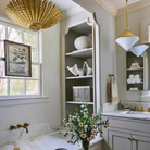 The Hampton Medium Chandelier from Visual Comfort and Co in antique gold in a bathroom.