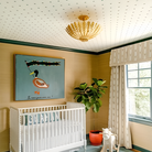 The Hampton Mini Chandelier from Visual Comfort and Co in antique gold in a child's bedroom.