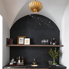 The Hampton Mini Chandelier from Visual Comfort and Co in antique gold in a lounge.