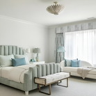 The Hampton Mini Chandelier from Visual Comfort and Co in burnished silver leaf in a guest bedroom.