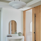 The Mollino Large Tiered Chandelier from Visual Comfort and Co in bronze in a guest bedroom.