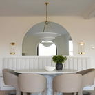 The Mollino Large Tiered Chandelier from Visual Comfort and Co in hand-rubbed antique brass over breakfast nook.