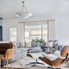 The Mollino Large Tiered Chandelier from Visual Comfort and Co in hand-rubbed antique brass in a lounge.