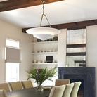 The Mollino Large Tiered Chandelier from Visual Comfort and Co in hand-rubbed antique brass in a dining room