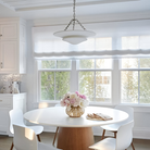 The Mollino Medium Tiered Chandelier from Visual Comfort and Co in polished nickel in a dining room