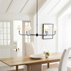 The Piaf Grande Chandelier from Visual Comfort & Co. in aged iron and ebonized oak in a dining room.