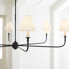 The Piaf Grande Chandelier from Visual Comfort & Co. in aged iron and ebonized oak in a living room.