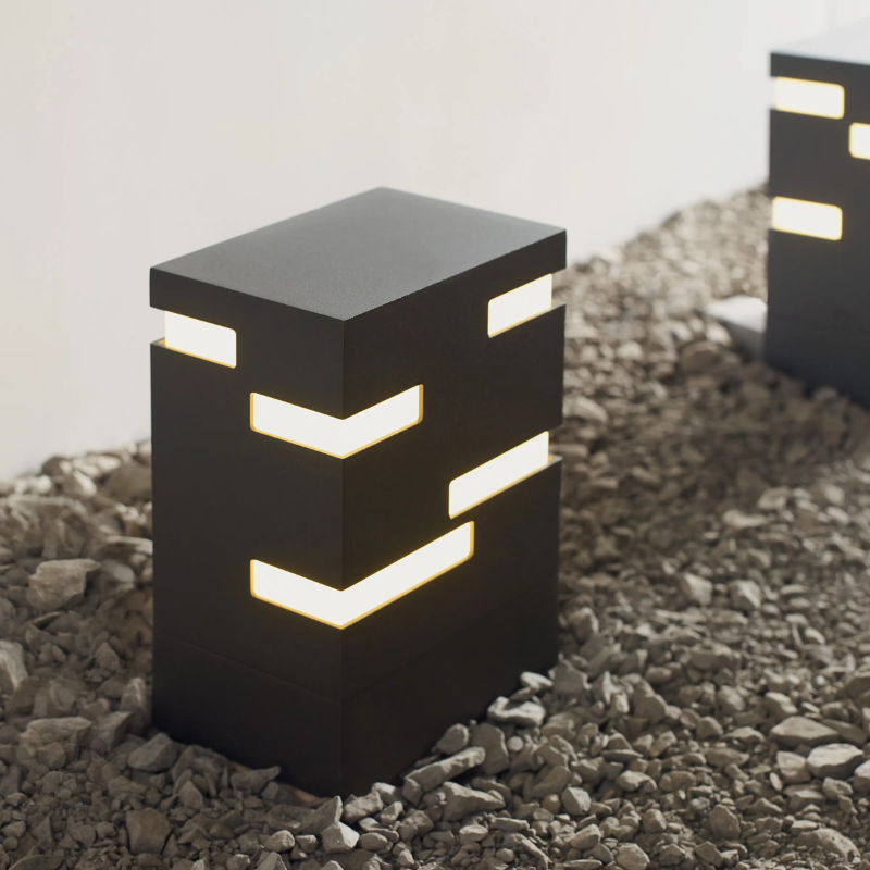 The Revel Outdoor Bollard from Visual Comfort and Co. in a close up lifestyle photograph.