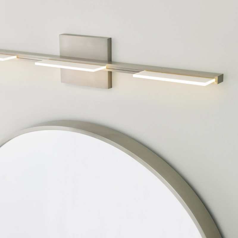 The Tris 3-Light Bathroom Sconce from Visual Comfort and Co in a home lifestyle photograph.