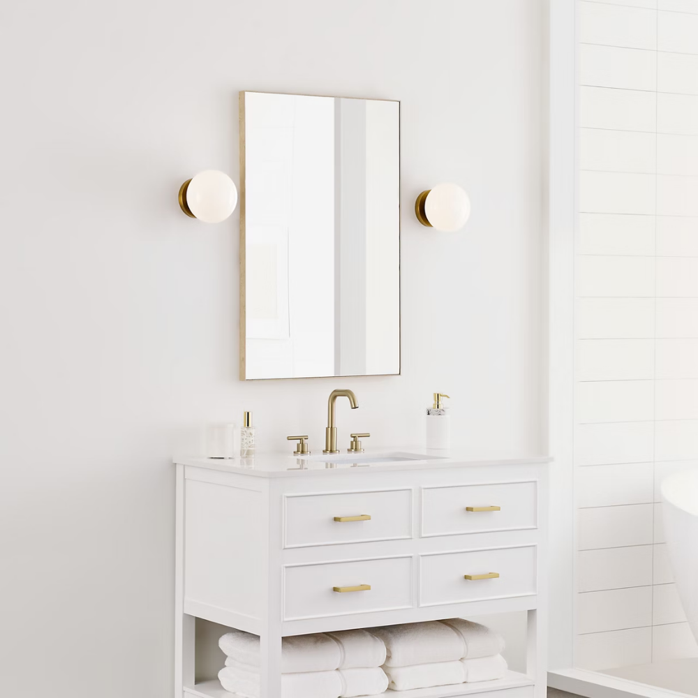 The Lune 1-Light Bath Sconce from Visual Comfort & Co in Burnished Brass in a bathroom.