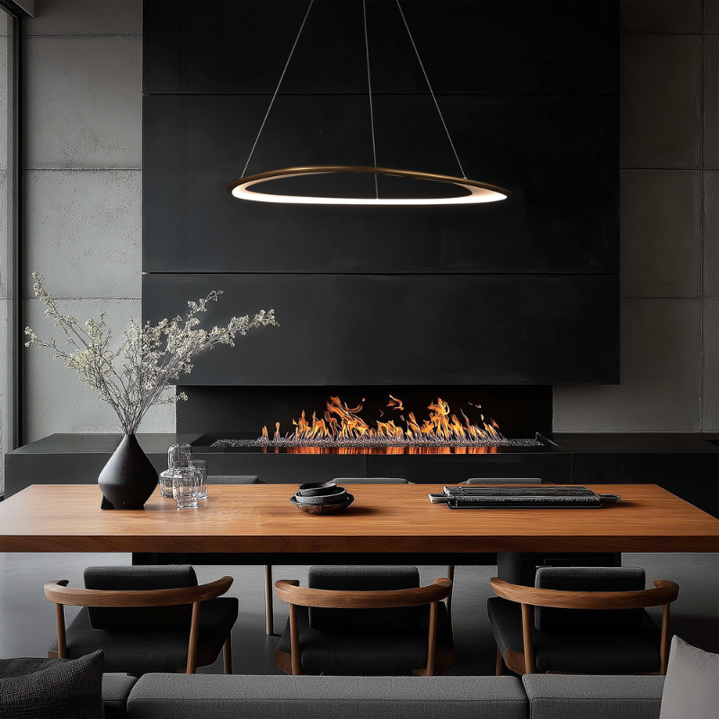 The 42-inch Oyster Color Select LED Pendant in Aged Brass by WAC Lighting over a dining table in a modern home.