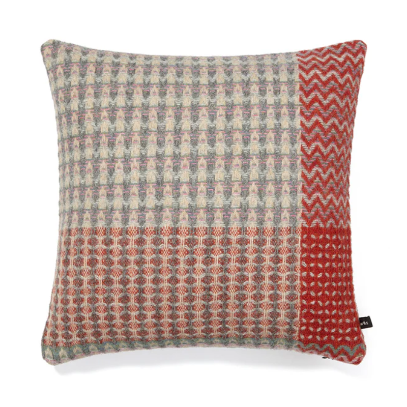 The Bryce Cushion by Wallace & Sewell. Made of 100% Shetland Wool. Cushion with muted sage green, pink, and red tones.
