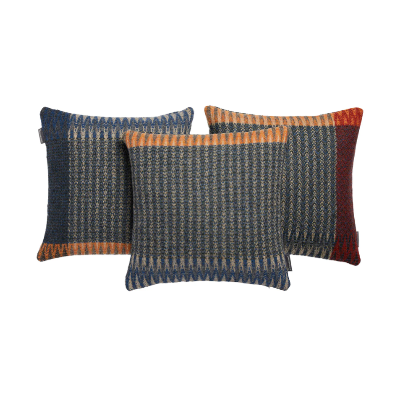The Cairngorm Shetland Tweed Cushion pairs denim and rosemary green with pale warp tones in rugged Shetland wool, finished with a striking orange border.