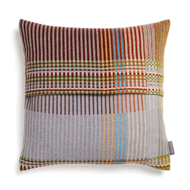 The Joan Cushion by Wallace & Sewell has light grey, burnt sienna, mossy green and highlights of pale yellow and blush sprinkled throughout.