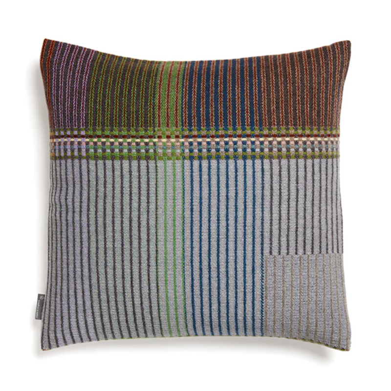 The Joan Cushion by Wallace & Sewell has light grey, burnt sienna, mossy green and highlights of pale yellow and blush sprinkled throughout.