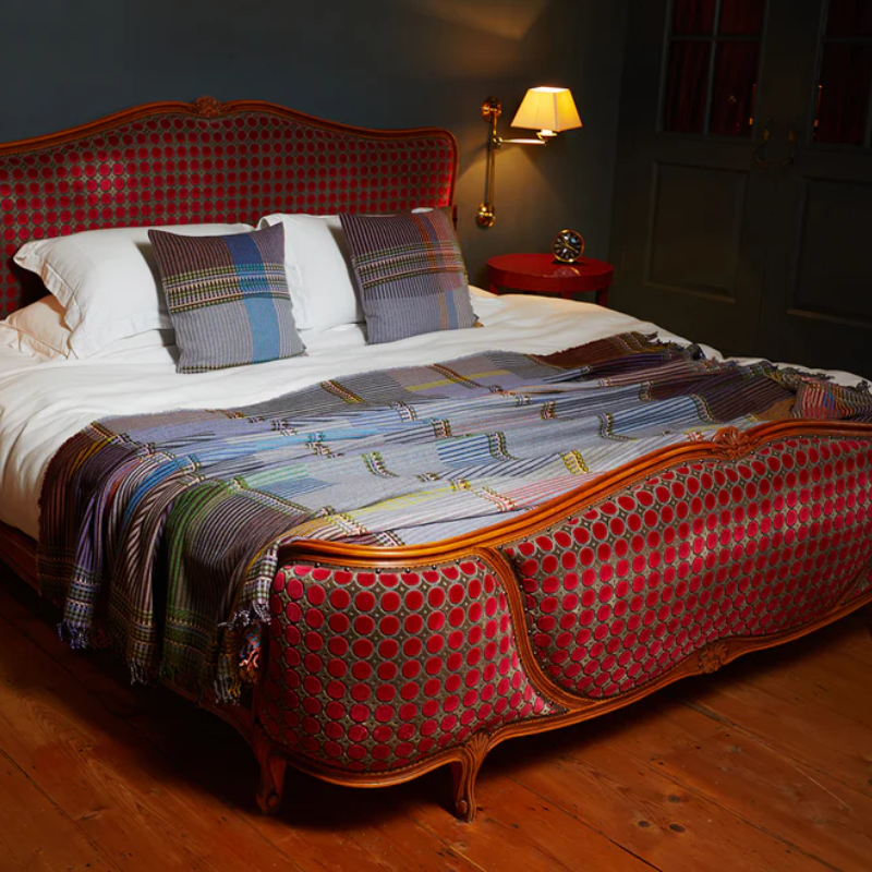 The Joan Throw by Wallace and Sewell in size large with matching Joan Cushions on a bed.