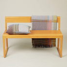 The Joan Throw by Wallace and Sewell on a bench with matching Joan Cushion.
