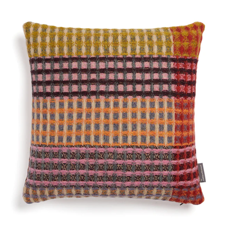 The Kew Cushion by Wallace and Sewell is made of natural shetland wool.   Pink and purple accents.