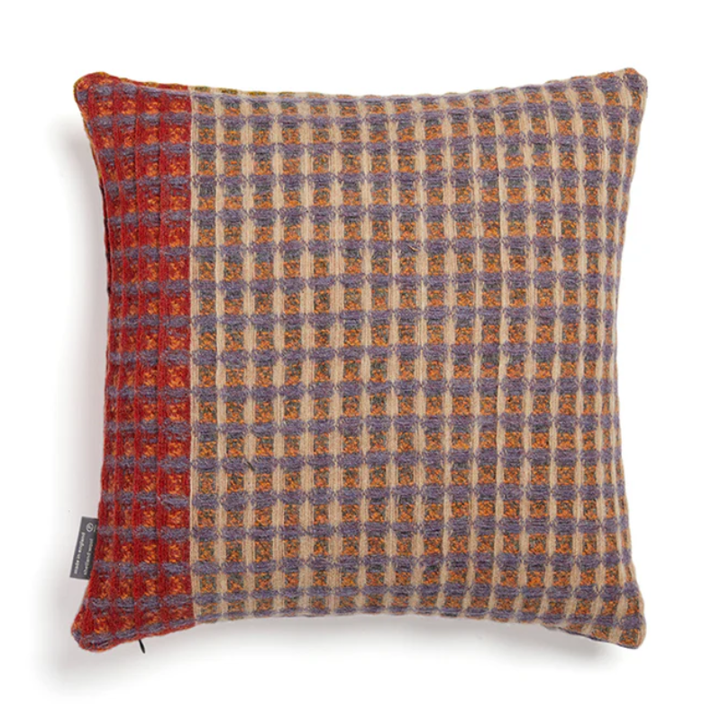 The Kew Cushion by Wallace and Sewell is made of natural shetland wool.   Red and purple accents.