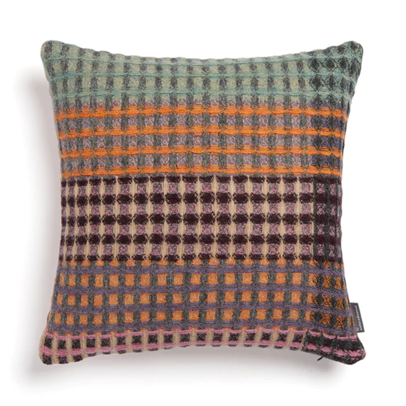 The Kew Cushion by Wallace and Sewell is made of natural shetland wool.   Blue and orange accents.