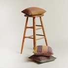 The Kew Cushion by Wallace and Sewell is made of natural shetland wool. Image showing three colorways of the same cushion.