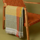 The Lismore Throw by Wallace & Sewell on the arm of a chair.