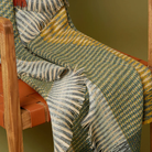 The Lismore Throw by Wallace & Sewell draped on a chair.