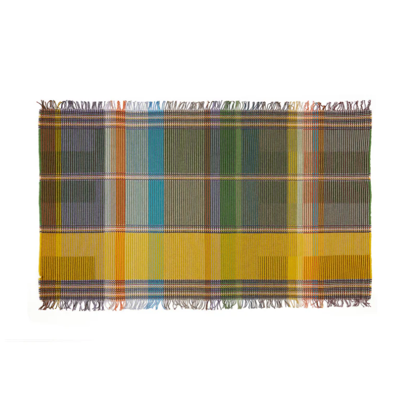 Wallace & Sewell’s Watson Throw blends green and yellow tones with grey and rust accents in merino lambswool, featuring fine pinstripes and a reversible design. Shown in size small.