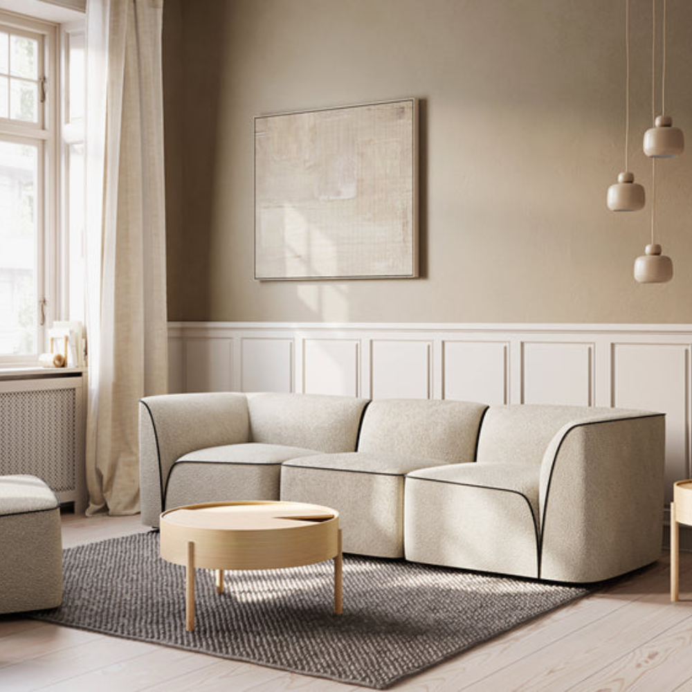 The Flora 3 seater standard in light sand in a living room.