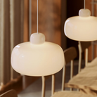 Two Stone Glass Pendants in the size Large by Woud over a dining table.
