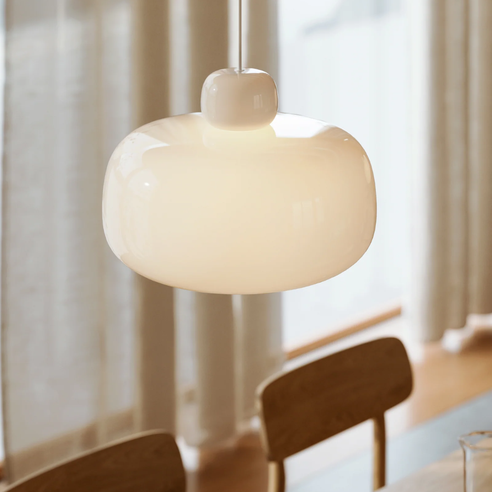 The Stone Glass Pendant in the size Large by Woud over a dining table.