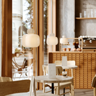 The Stone Glass Pendant in the size Small by Woud over a cafe table in a commercial environment,