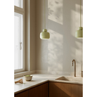 The small Stone Pendant from Woud in matcha over a kitchen sink.