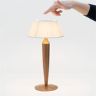 The matte gold Flaminia from Zafferano with a hand touching the top.