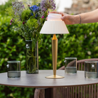 The matte gold Flaminia from Zafferano is on the table at the outdoor cafe.