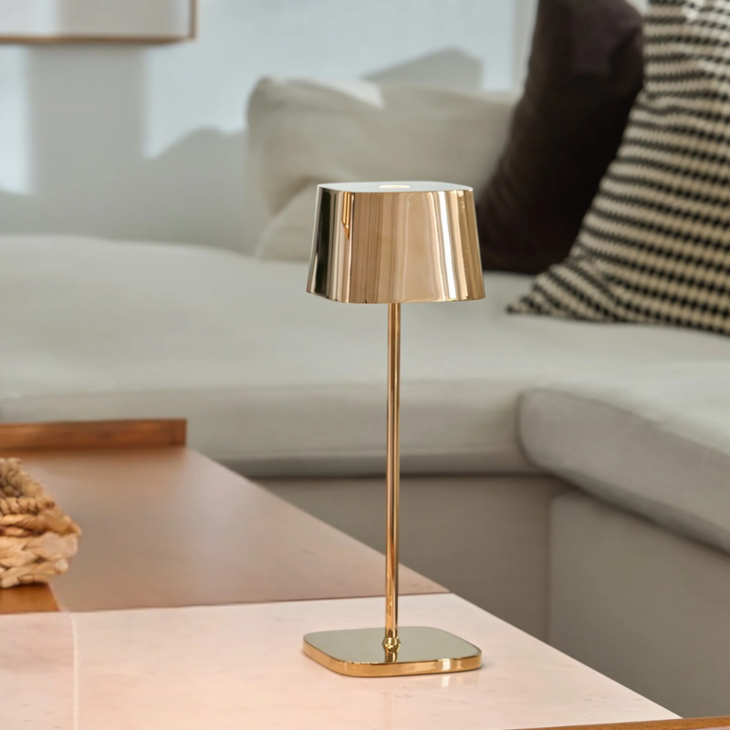 The rose gold Ofelia Pro cordless lamp from Zafferano in a family area.