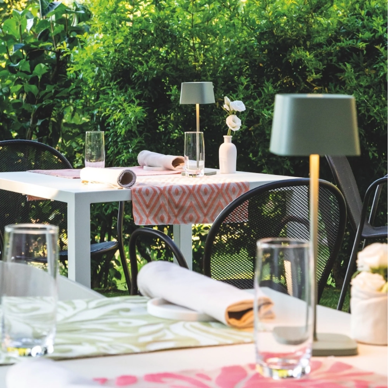 The sage Ofelia Pro cordless lamp from Zafferano in a cafe.