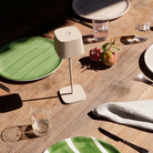 The sand Ofelia Pro cordless lamp from Zafferano in a dining area.