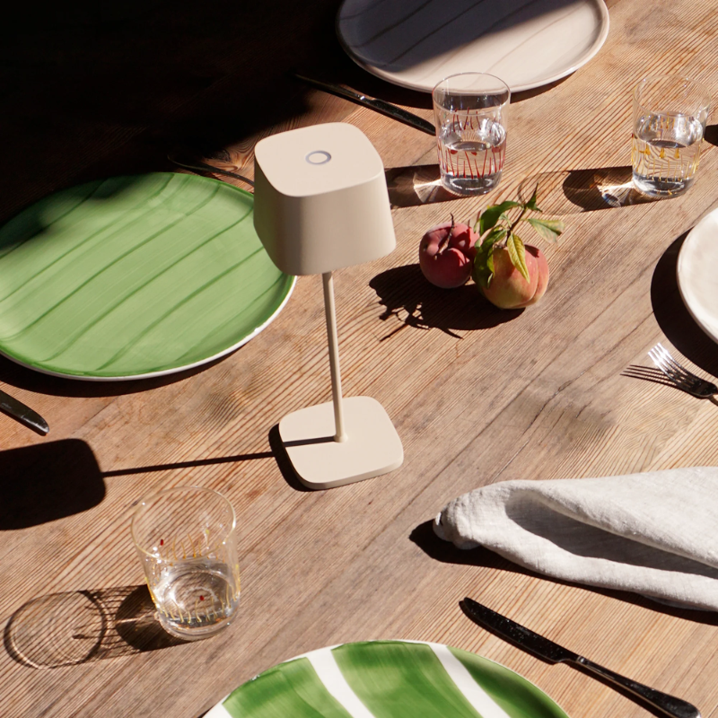 The sand Ofelia Pro cordless lamp from Zafferano in a dining area.