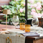 The sand Ofelia Pro cordless lamp from Zafferano in a dining setting.