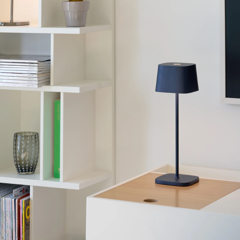 The steel blue Ofelia Pro cordless lamp from Zafferano in a family room.