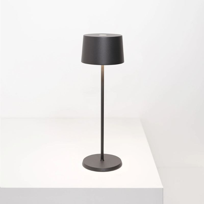 The dark gray Olivia Pro cordless lamp from Zafferano on a tabletop.