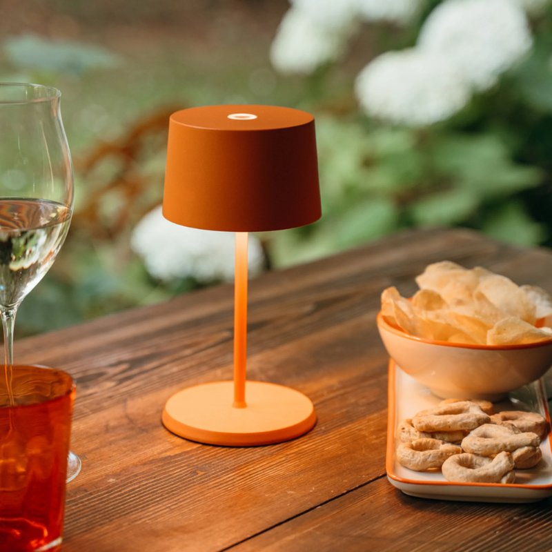 The orange Olivia Pro Mini from Zafferano on an outdoor dining table.