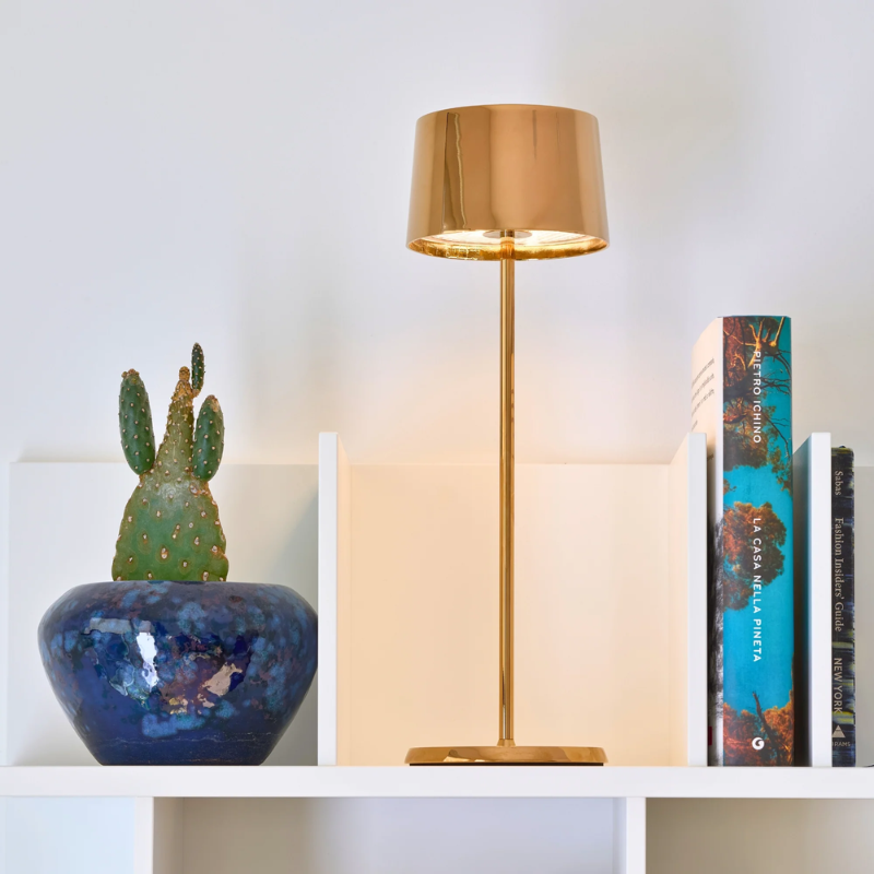 The rose gold Olivia Pro cordless lamp from Zafferano in a living room.