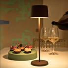 The rust Olivia Pro cordless lamp from Zafferano in a dining room.