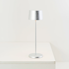 The silver leaf Olivia Pro cordless lamp from Zafferano on a dining table.
