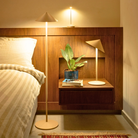 The gold Pina L Desk Lamp from Zafferano in a modern bedroom.