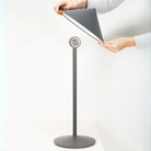 The titanium Pina L Desk Lamp from Zafferano hand holding the top head.